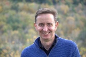 Headshot of a man with trees in the background